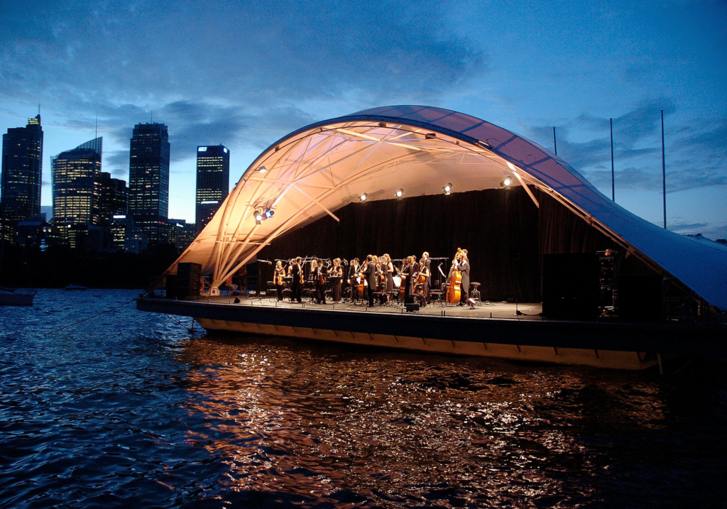 The Sydney Symphony Orchestra performs on a floating aquashell in Sydney Harbour on 27 January 2006 Image source: Paul McConnell via Getty Images
